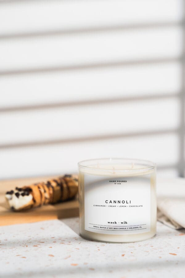 A candle sitting on top of a table next to an ice cream cone.