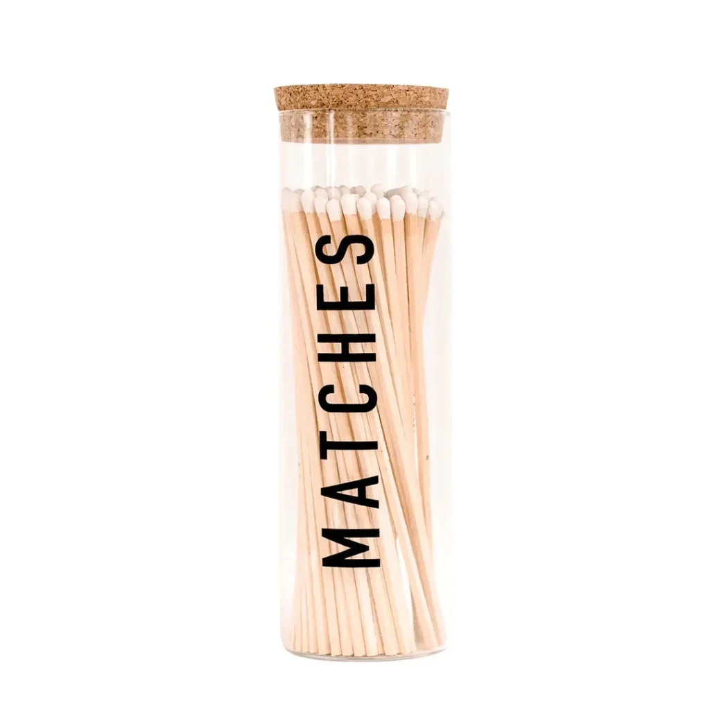 A glass tube with matches on top of it.