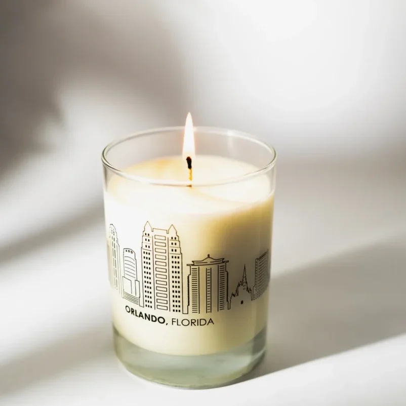 A candle is lit in front of the city skyline.